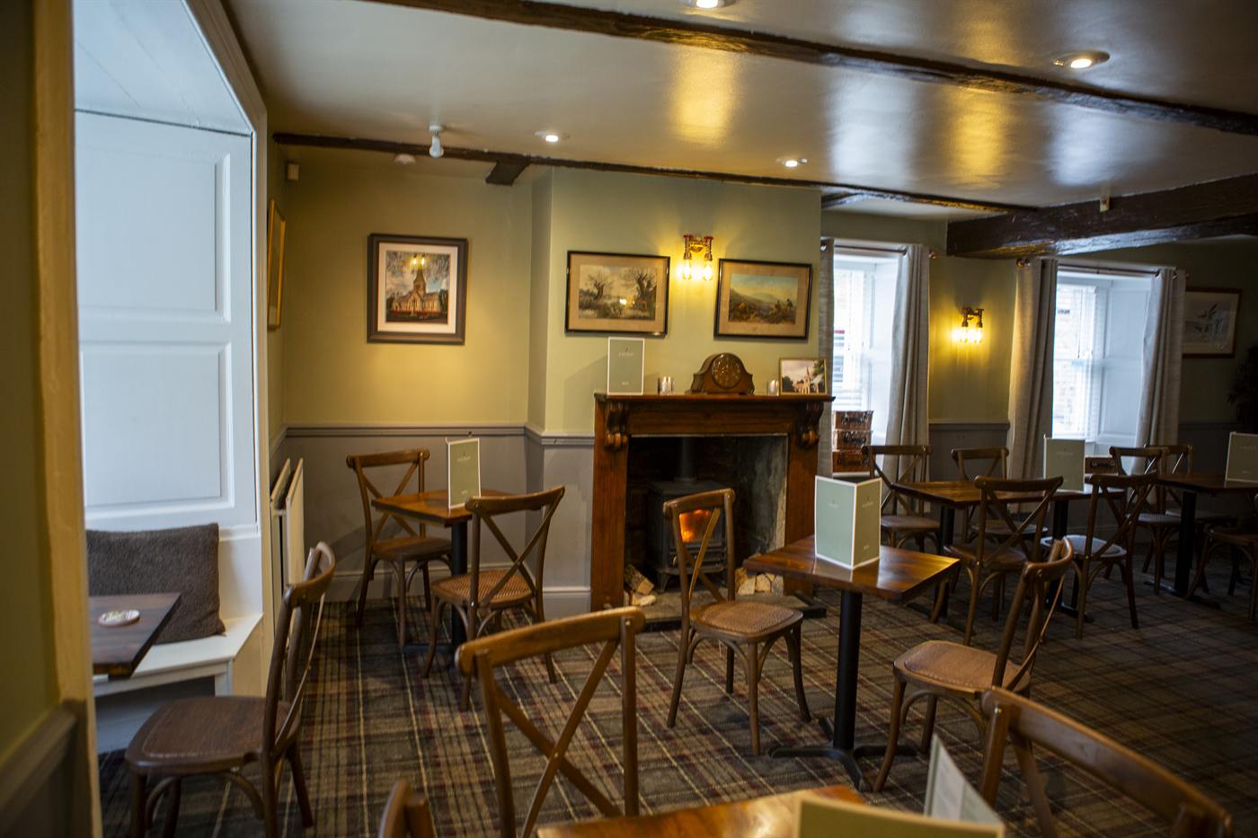 Dining room with window seats, pictures on the walls and a fireplace