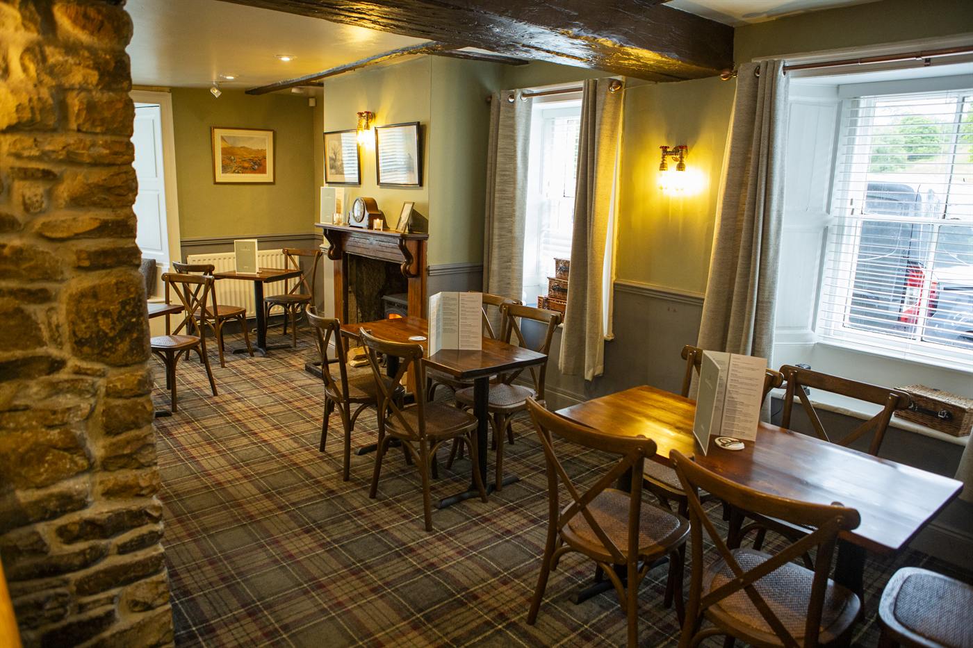 Dining area with a stone pillar and tables by the window
